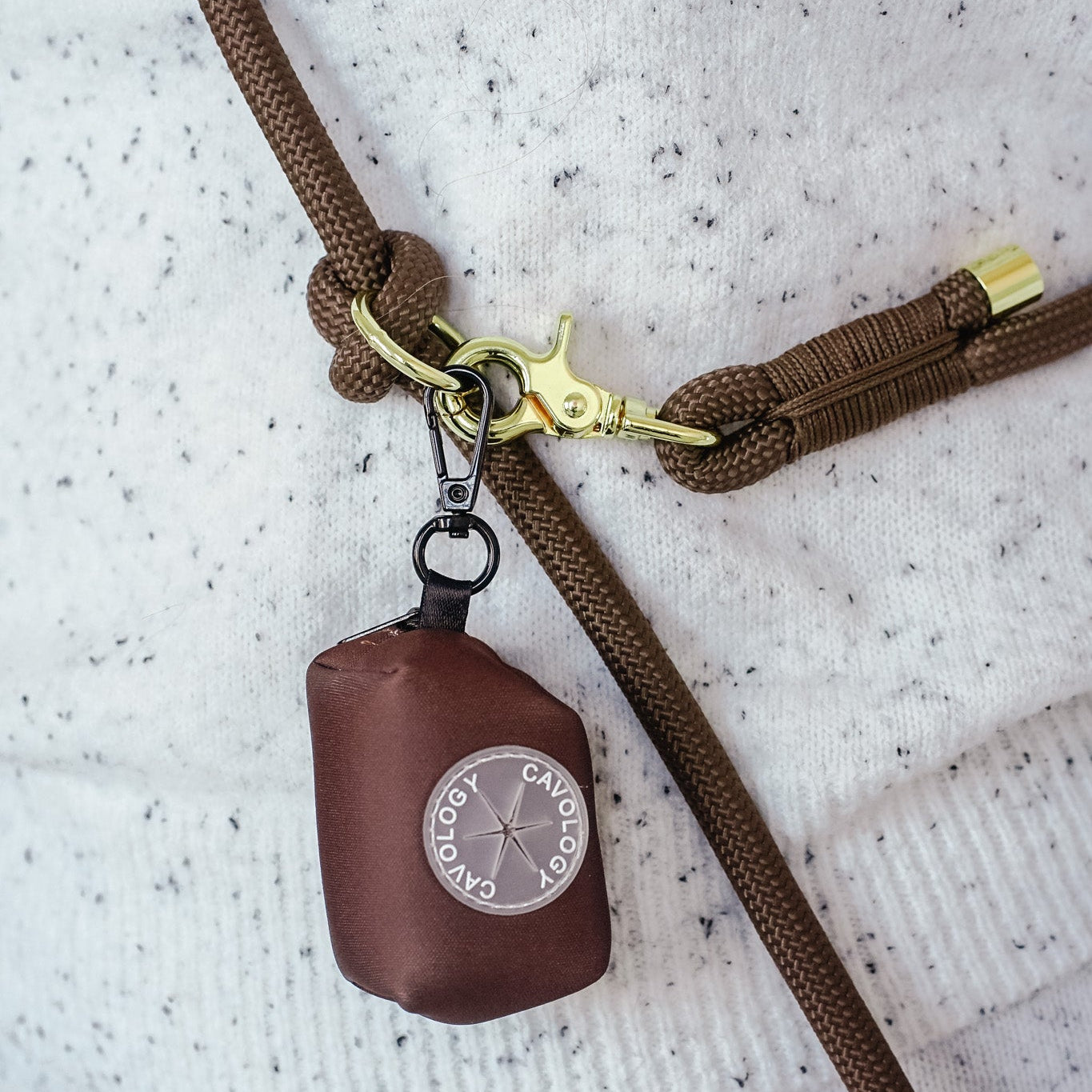 Cavology waste bag dispenser hanging from matching braided rope dog leash in chocolate brown